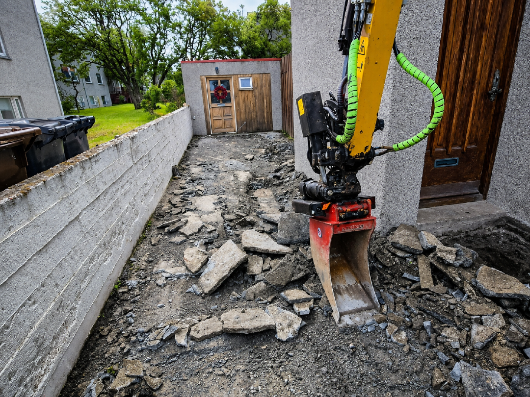 Grafa að brjóta upp gamalt steypt plan fyrir nýja hellulögn